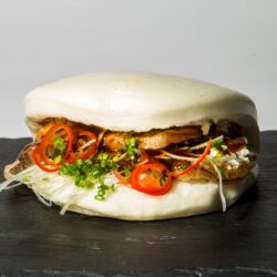 Bao japonês recheado com entremeada grelhada, cebola e molho