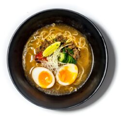 Ramen kimchi servido em taça preta com ovo marinado, carne e caldo picante