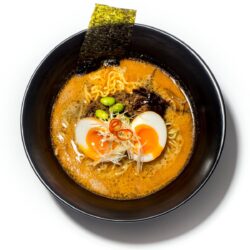 Ramen tantanmen servido em taça preta com carne picada, ovo marinado e noodles