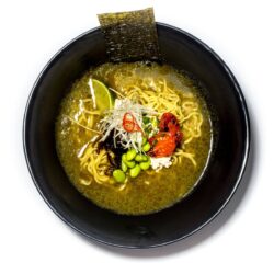 Ramen vegan servido em taça preta com legumes, noodles e caldo vegetal