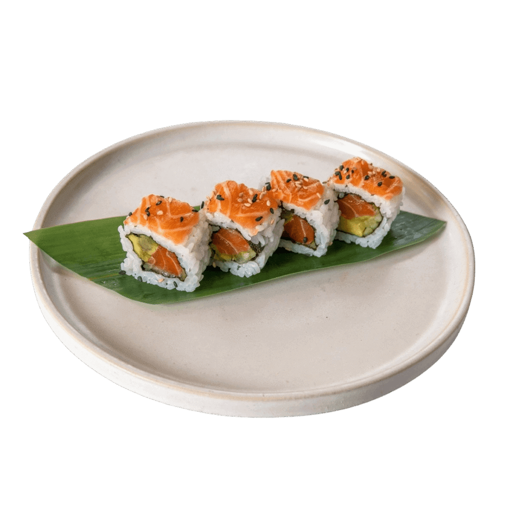 Uramaki Califórnia – Quatro peças de uramaki com salmão, abacate e pepino, cobertas com sementes de sésamo e servidas sobre folha de bambu.