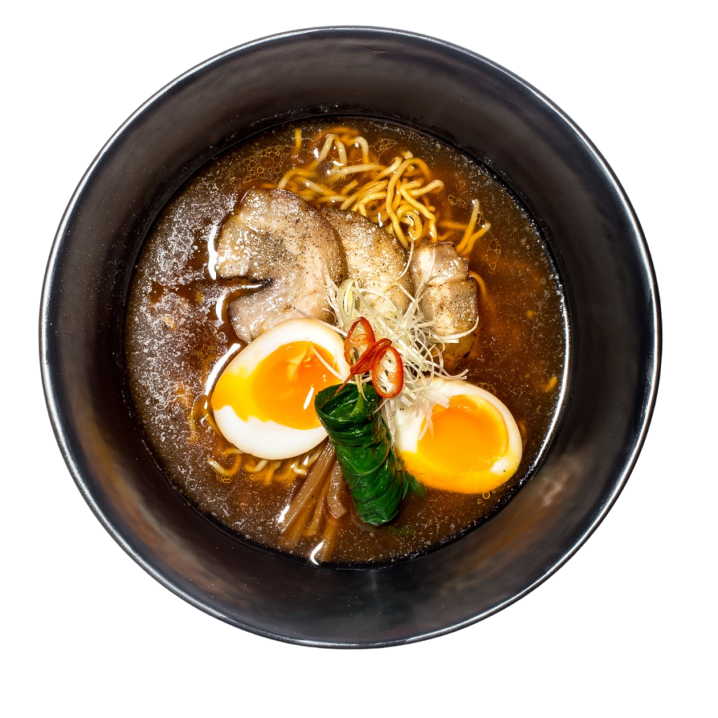 Ramen shoyu servido em taca preta com carne ovo marinado e caldo de soja